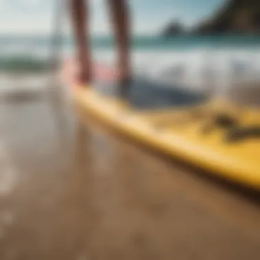 Close-up of paddle and SUP board on a sandy beach