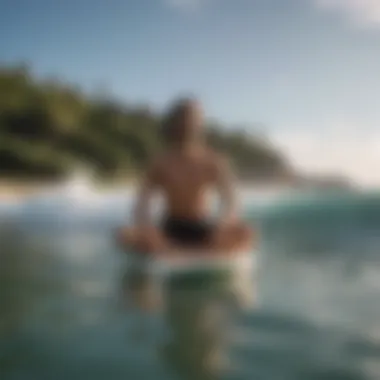 Surfer meditating on a surfboard after yoga session