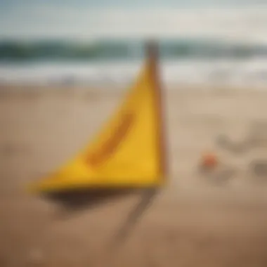 A vivid yellow flag displayed prominently on the sandy beach next to the surf.